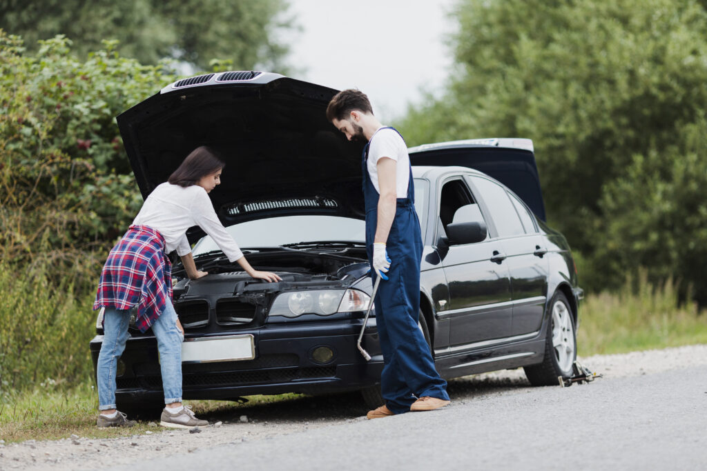 man woman checking car engine